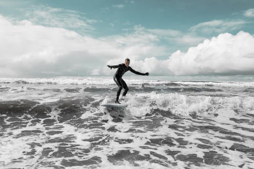 Free Man Wearing Wet Suit Surfing Stock Photo