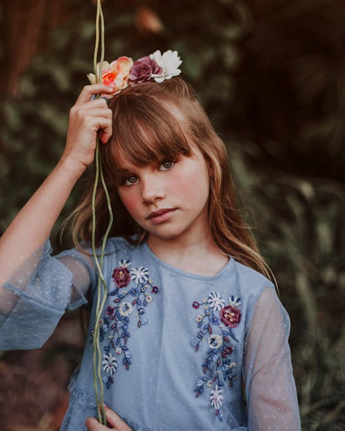 Ragazza In Vestito Floreale Bianco E Blu Che Tiene Fiore Rosso E Bianco