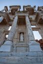 From below of aged stone church exterior with columns and sculpture under sky in daylight