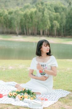 一名年轻女子在湖边，被大自然和鲜花环绕，享受着宁静的时刻