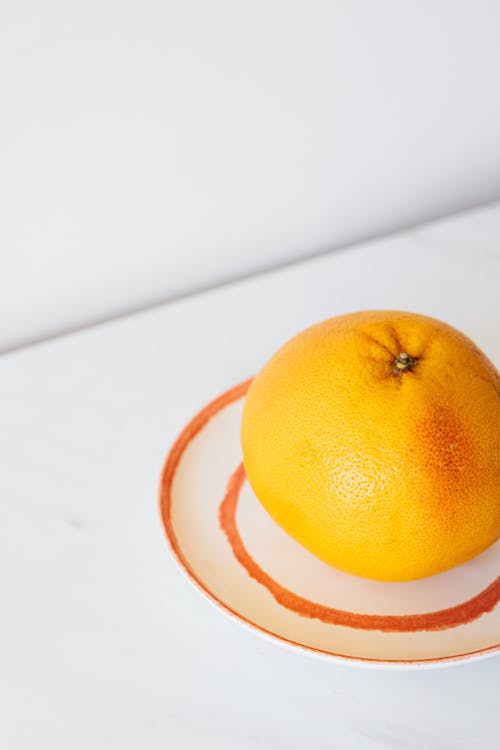 Grapefruit on plate on white table