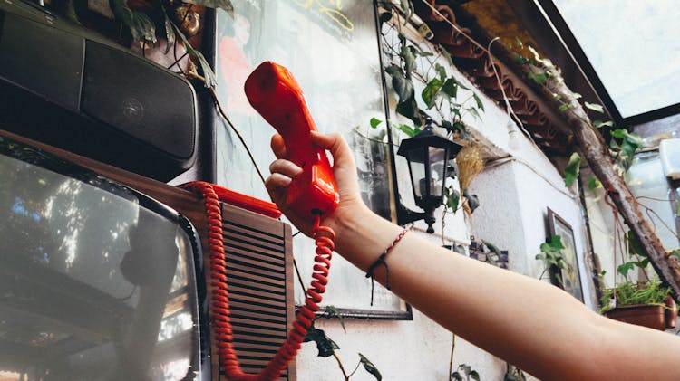 Close-Up Shot Of A Person Holding A Landline Phone