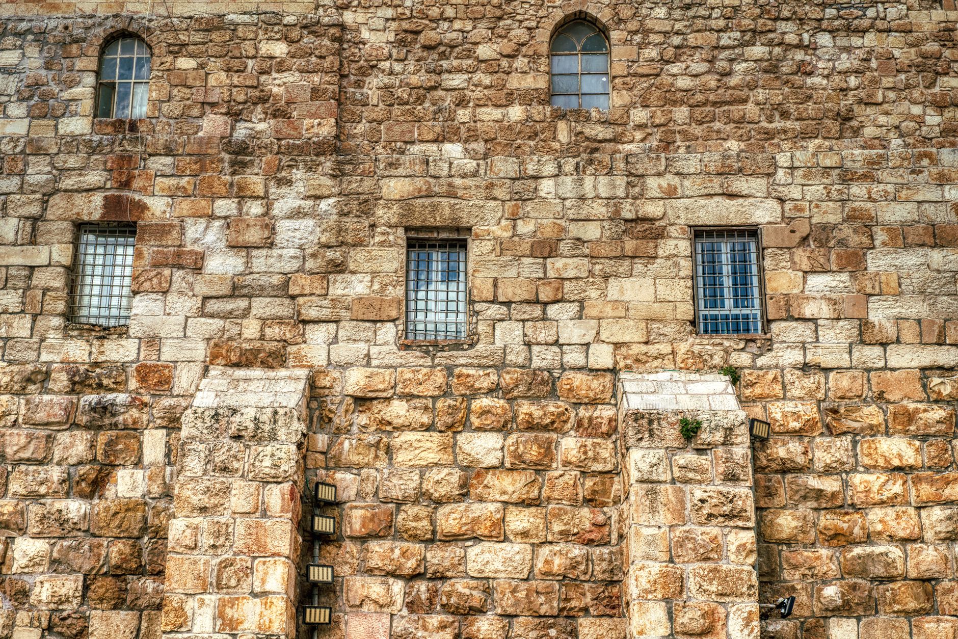 Historic stone facade with windows and barred design showcases classic architecture.