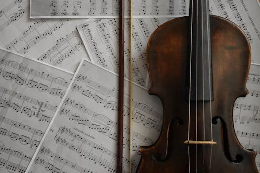 A detailed view of a violin resting on musical sheets, capturing an artistic arrangement.