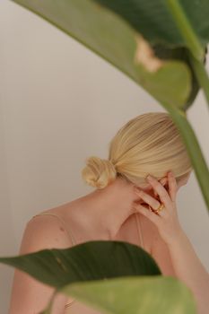 部分金发女子的审美肖像被树叶遮掩，传达出优雅之感