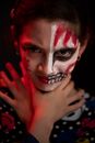 Concentrated adolescent with terrible greasepaint on half face