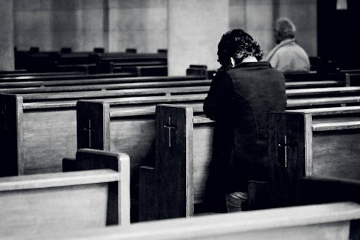 unrecognizable men praying in old catholic church