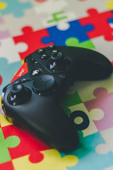 Black wireless game controller on a vibrant puzzle piece mat, perfect for gaming themes.