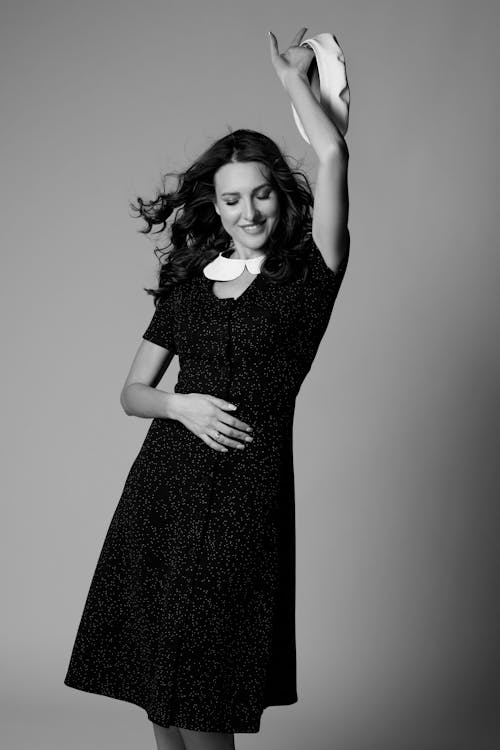Monochrome Photo of a Woman in a Dress Posing with Her Arm Up
