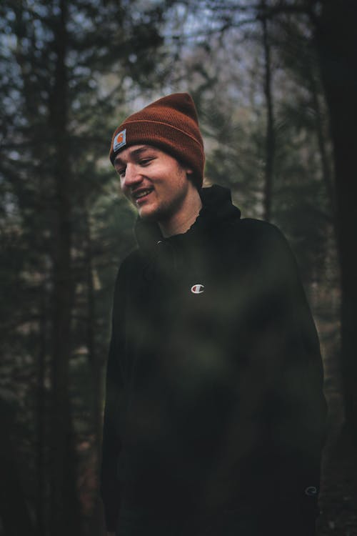 Happy young man standing in forest