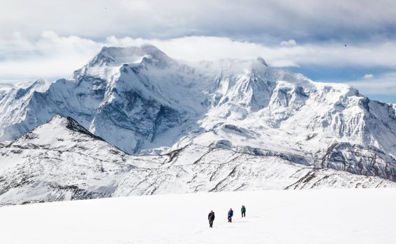 一行人在白雪覆盖的喜马拉雅山徒步旅行，欣赏着令人惊叹的山景