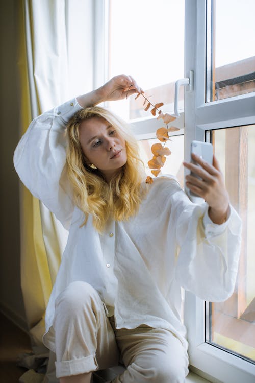 Free Woman in White Shirt Holding her Smartphone Stock Photo