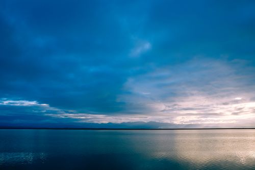 Free Magnificent view of endless calm sea under majestic cloudy sky in evening Stock Photo