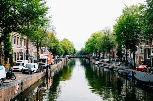 Free Picturesque view of old stone houses located on city canal shore on clear spring day Stock Photo