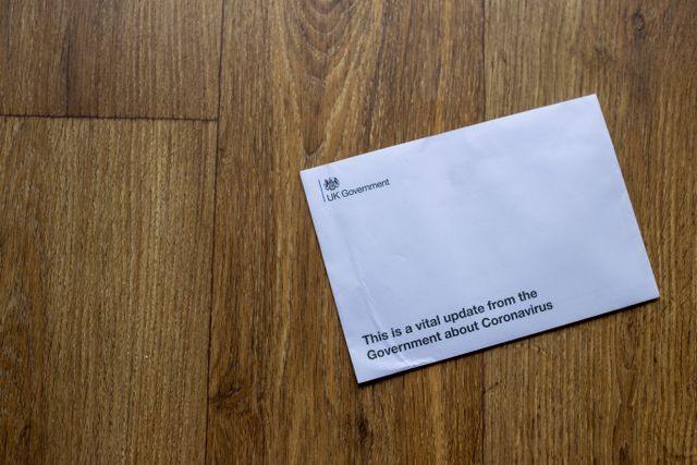 A UK government envelope on a wooden floor, representing an HMRC ATED penalty notice