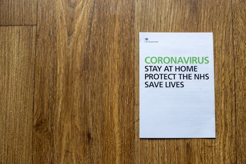 Top view wooden table with sheet of paper with advises regarding behavior during coronavirus pandemic