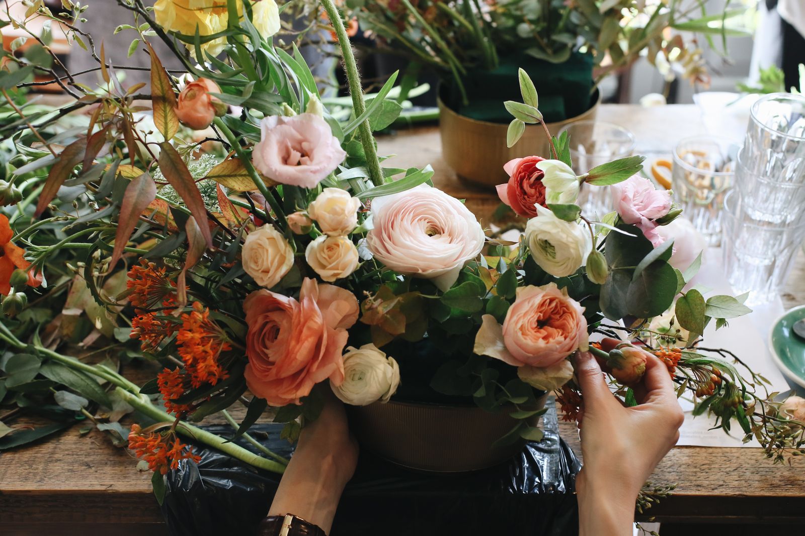 Manos componiendo un ramo de flores en un taller floral