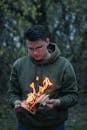 Focused male teen burning diary in forest