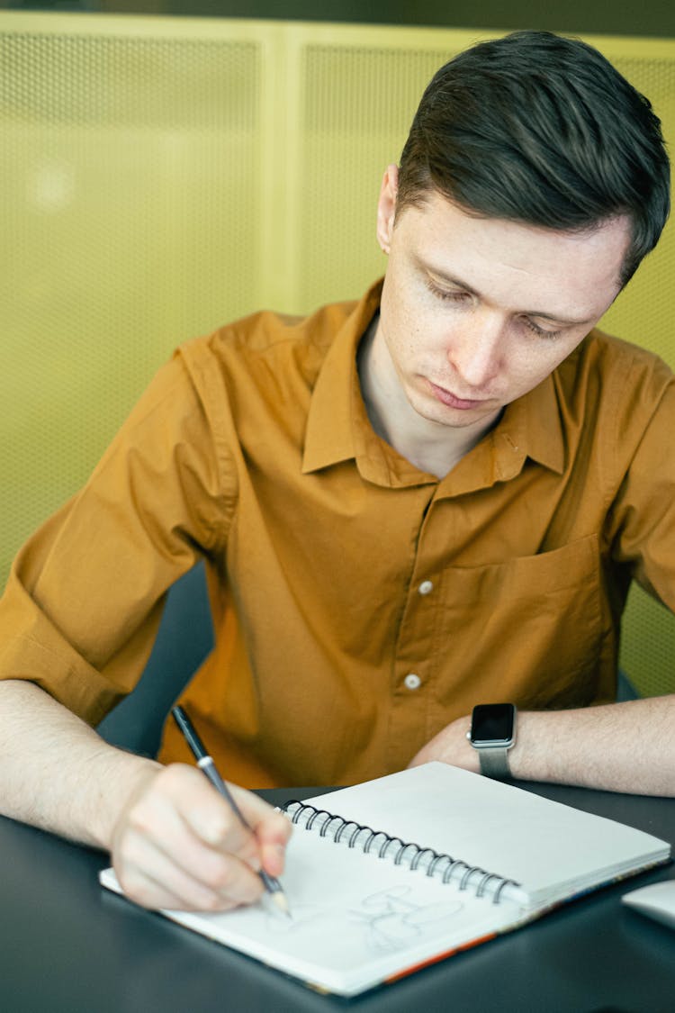 Man Drawing On His Sketchbook