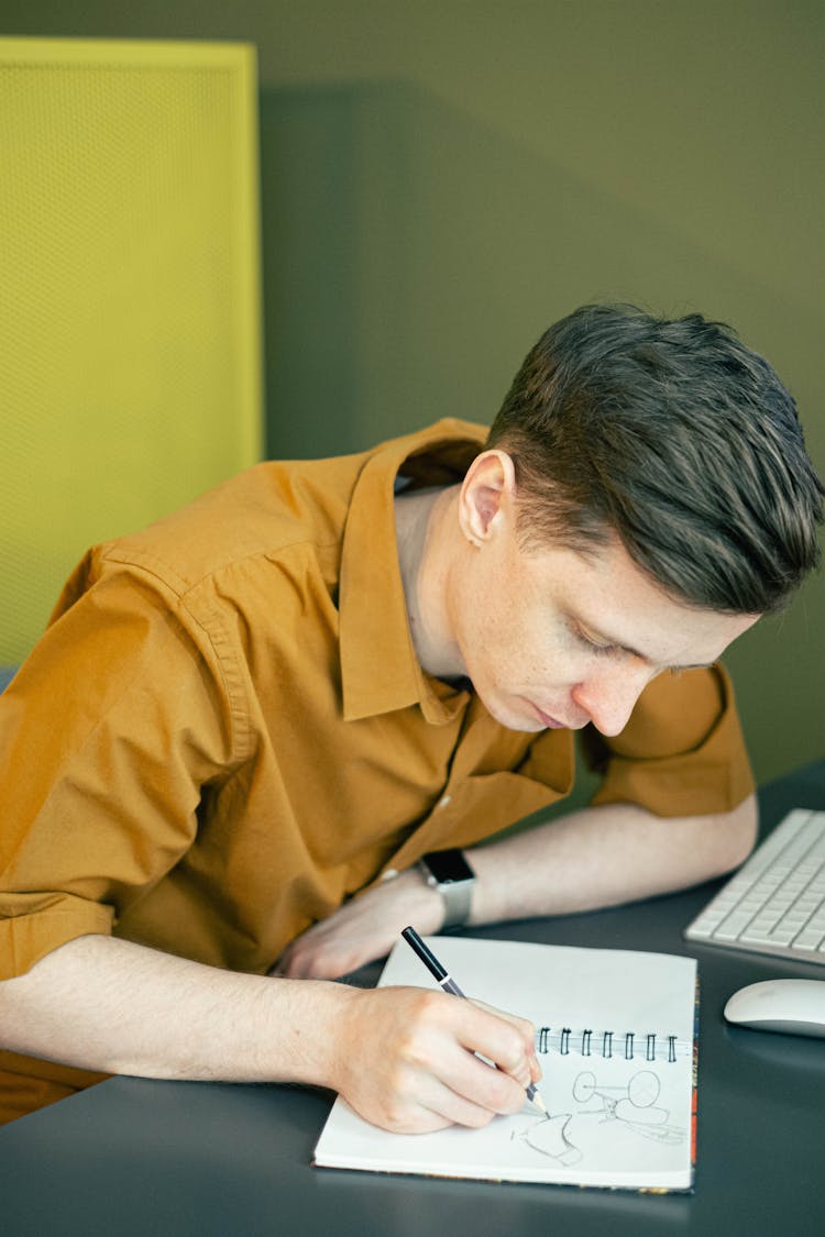 Man Drawing On His Sketchbook