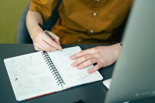 Person Sketching on a Notebook