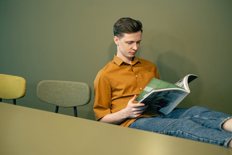 Man Sitting And Reading A Magazine