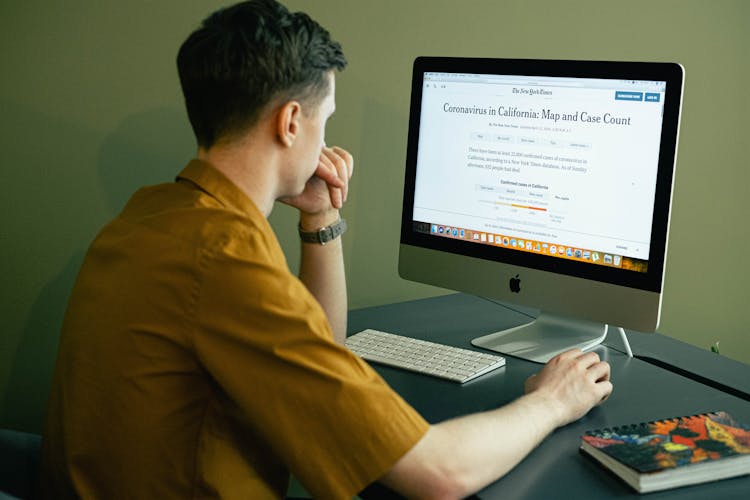 Man Reading The News On A Computer