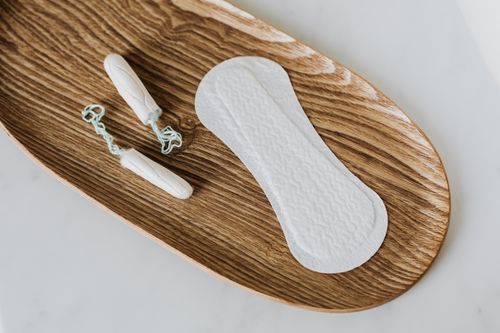 Free From above of set of cotton tampons and daily liner placed on wooden stand on white surface Stock Photo