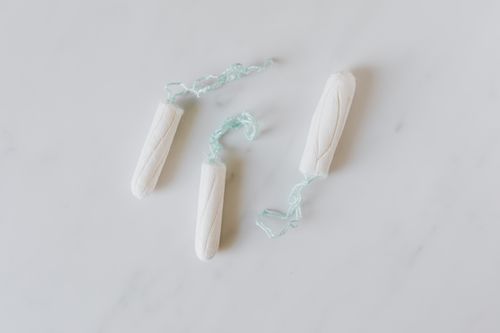 Free Top view of three hygienic cotton tampons placed on white marble patterned surface Stock Photo