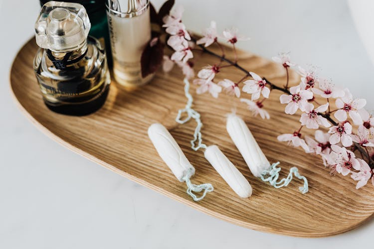 Wooden Tray With Perfume Cosmetic Products Hygienic Tampons And Flower Branch