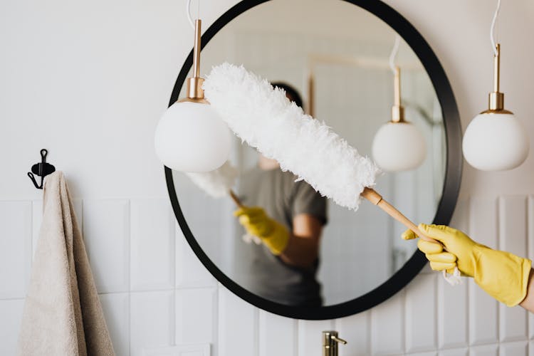 Crop Woman Dusting Lamp During Housework