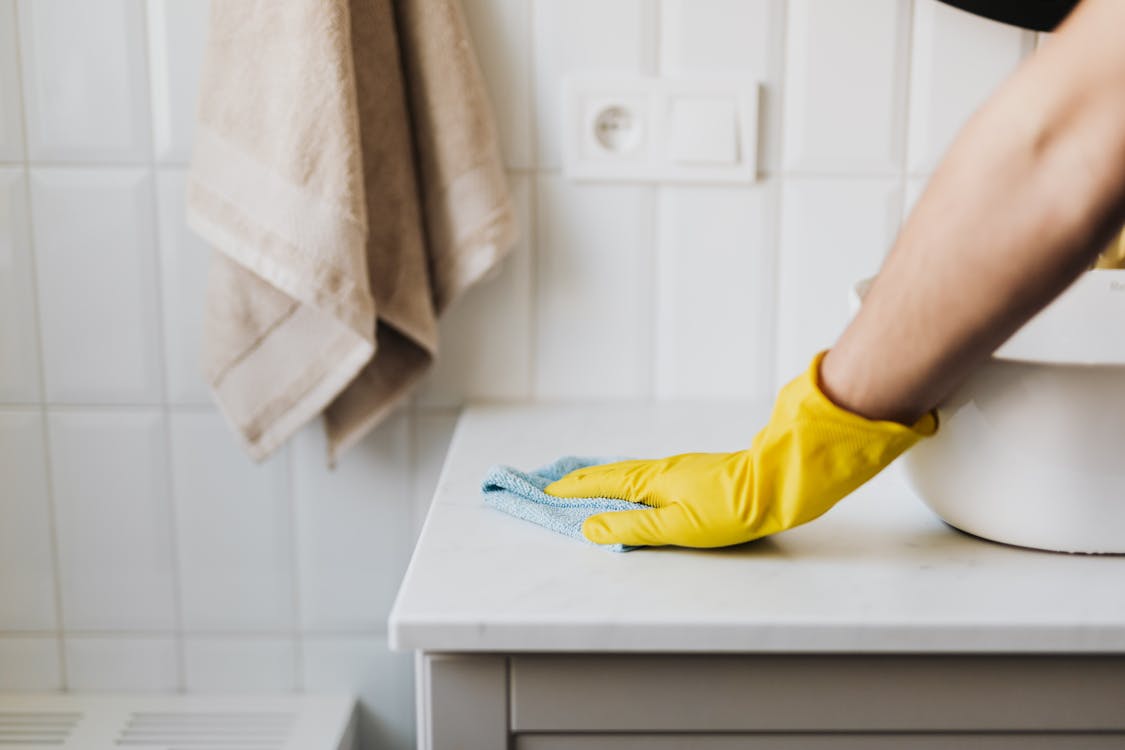 Free Crop housewife cleaning surface near sink Stock Photo