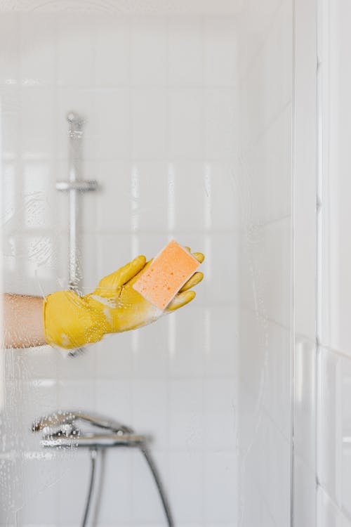 Free Person in glove washing shower cabin door Stock Photo