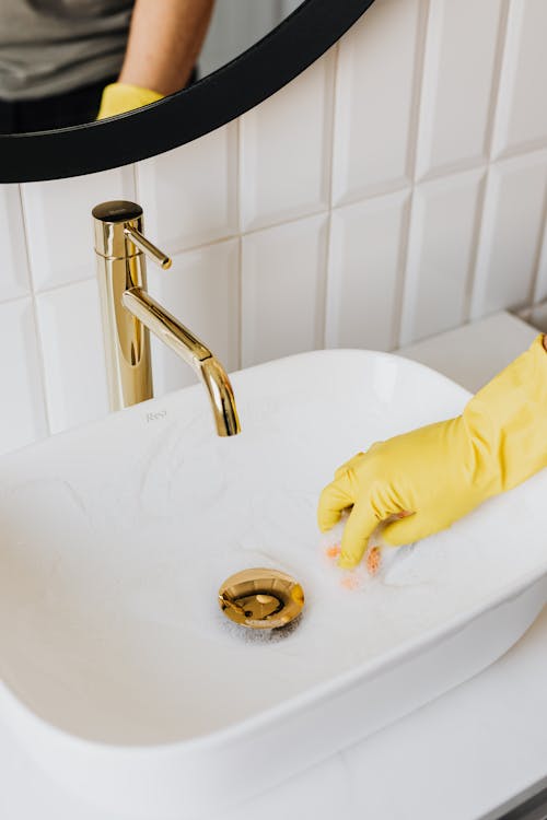 Free Faceless man cleaning sink in bathroom Stock Photo