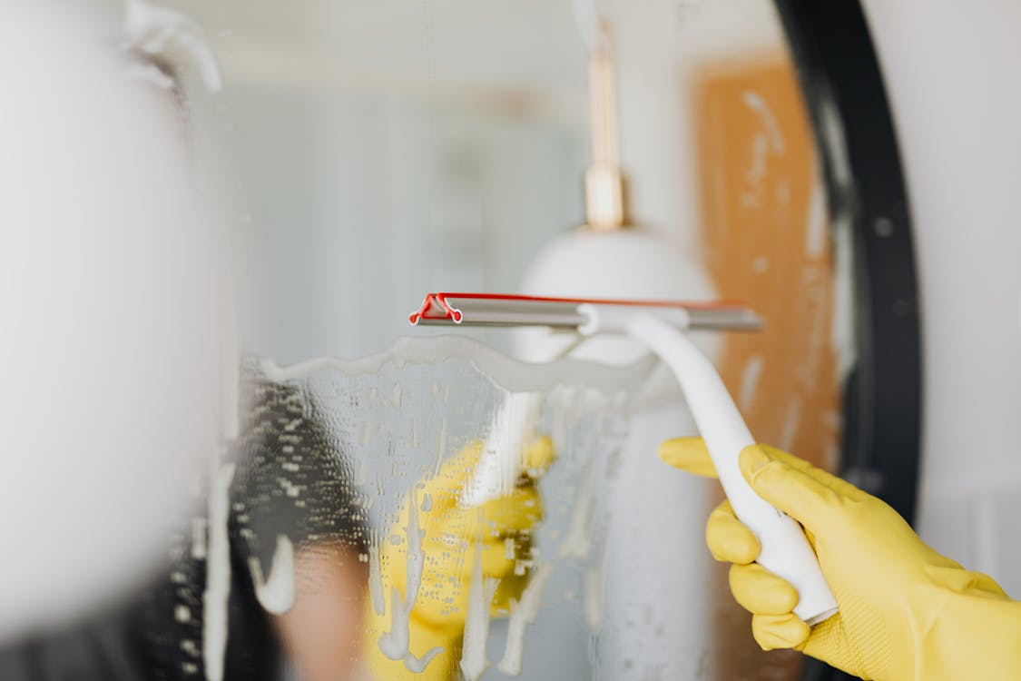 Free Faceless person removing water from mirror Stock Photo