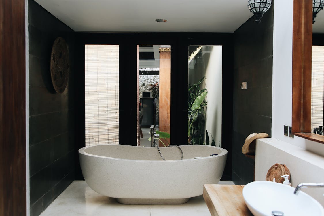 White Bathtub Near Brown Wooden Table