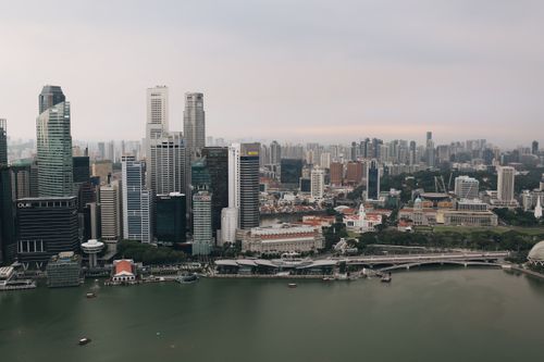 Free Stunning aerial view of Singapore's skyline with skyscrapers and river under a gloomy sky. Stock Photo