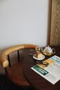 Chair against table served with newspaper eyeglasses and tea pot