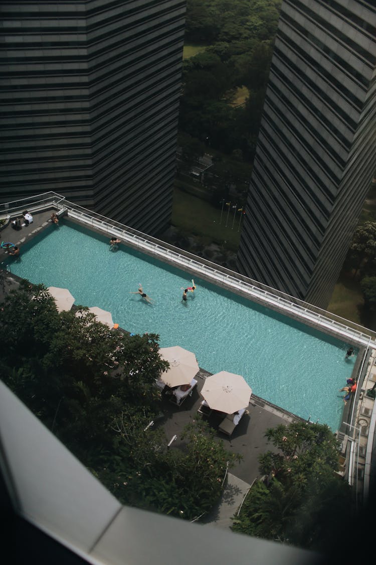 People Swimming In Pool In Hotel In City