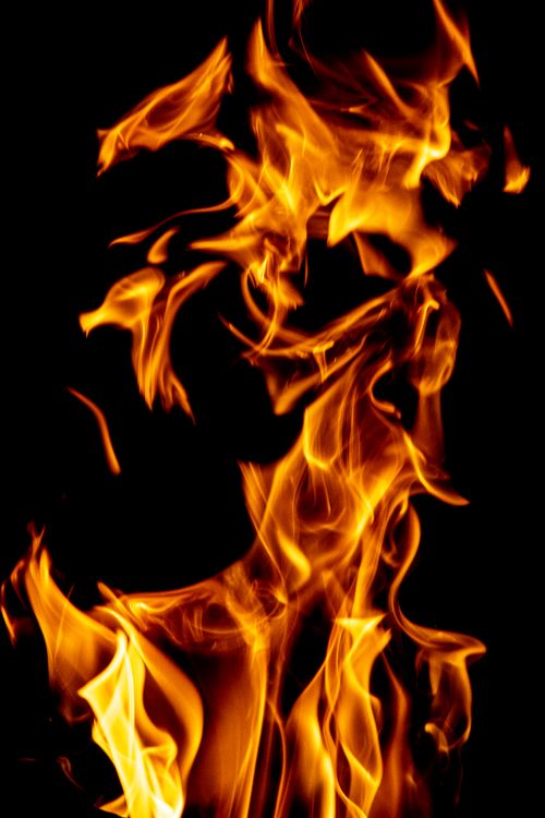 Free A vivid capture of flames dancing, highlighting the vibrant energy of fire against a dark backdrop. Stock Photo