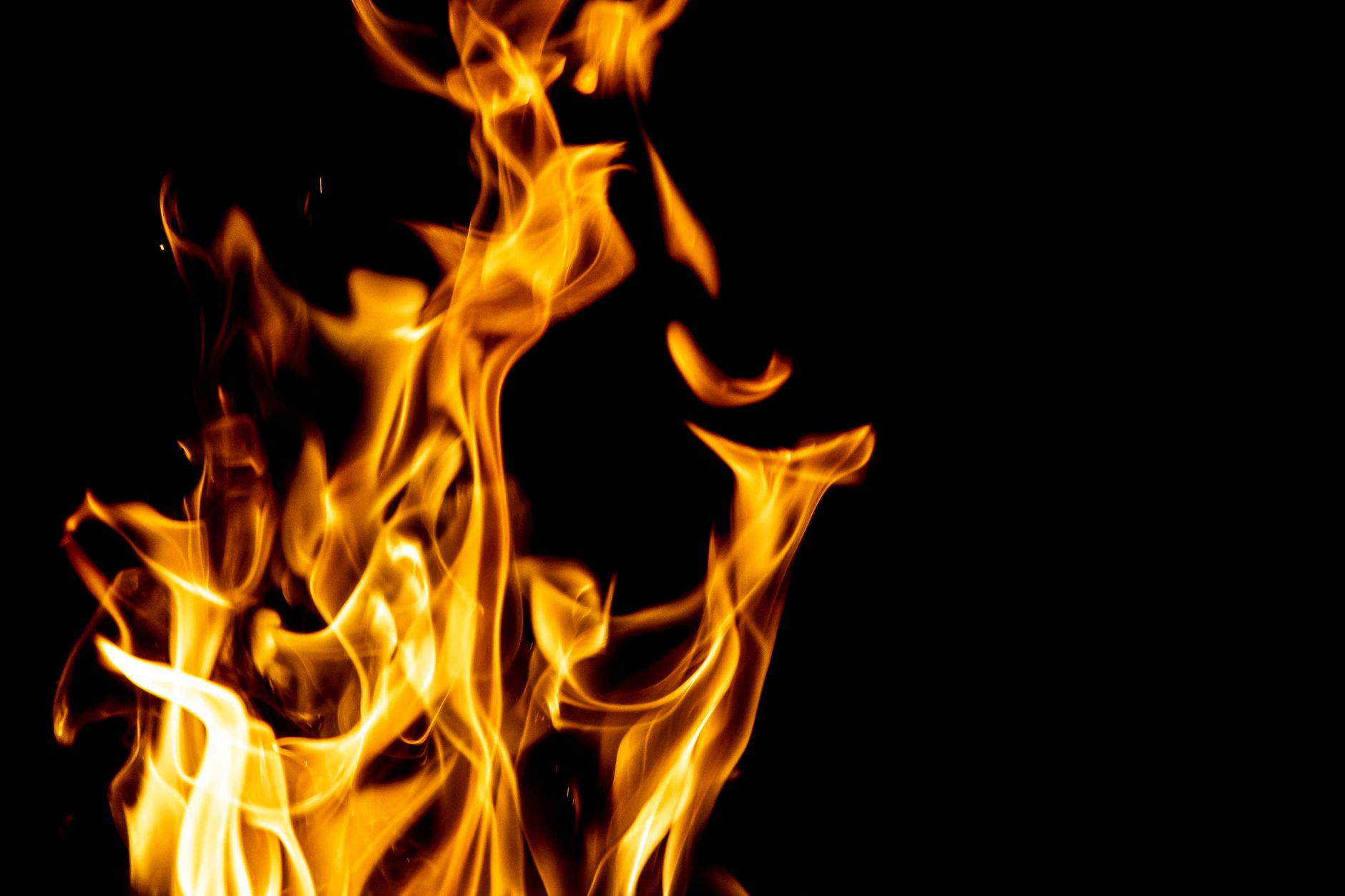 Dynamic capture of bright flames contrasted against a dark backdrop, showcasing fire's movement.