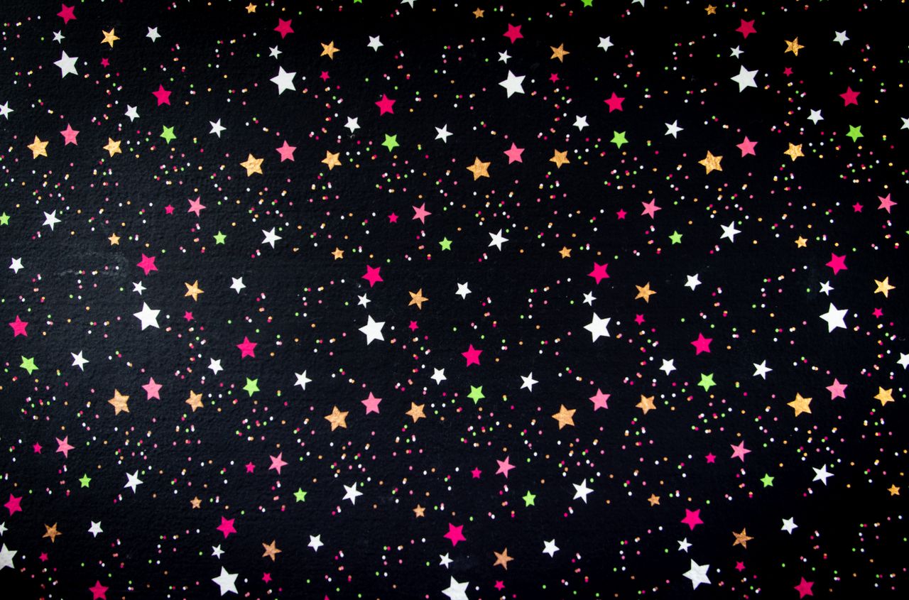vibrant star pattern with colorful dots against a black background per