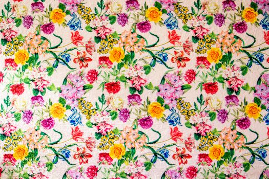 Colorful floral pattern with roses and leaves on intricate textile design.