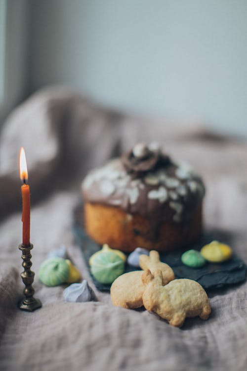 Various Easter cookies and cake composed with burning candle