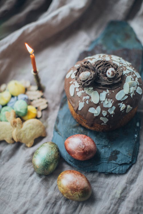 Easter eggs and cake on table with cookies and candle