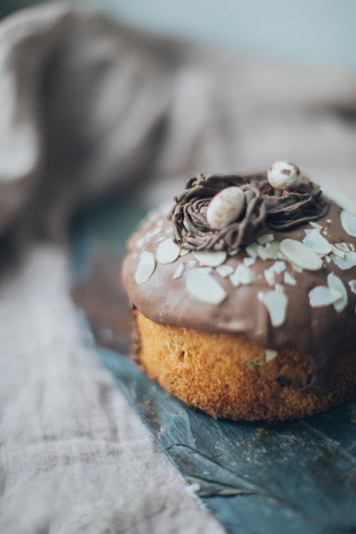 Yummy cake with chocolate topping and almond flakes served on table