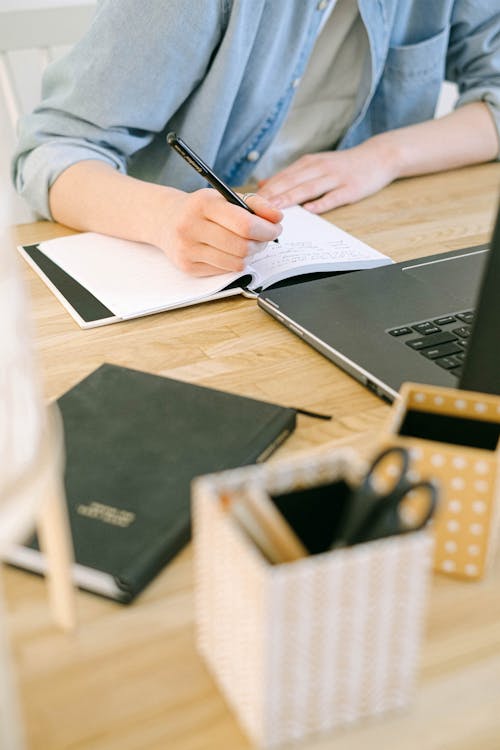 Free Person Writing on a Notebook Stock Photo