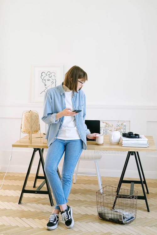 Woman Leaning Against Desk in Home Office