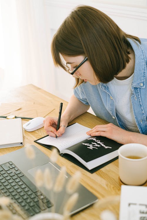 Free Woman Writing in Notebook Stock Photo