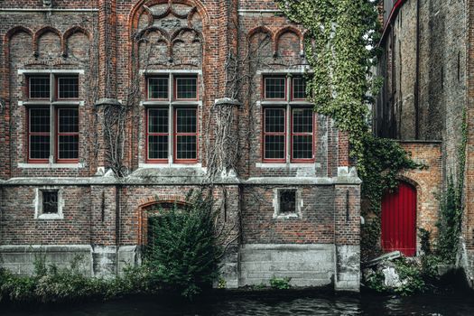 Fragment of exterior of ancient historic brick building with ornamental walls located on Steenhouwers Canal in Bruges